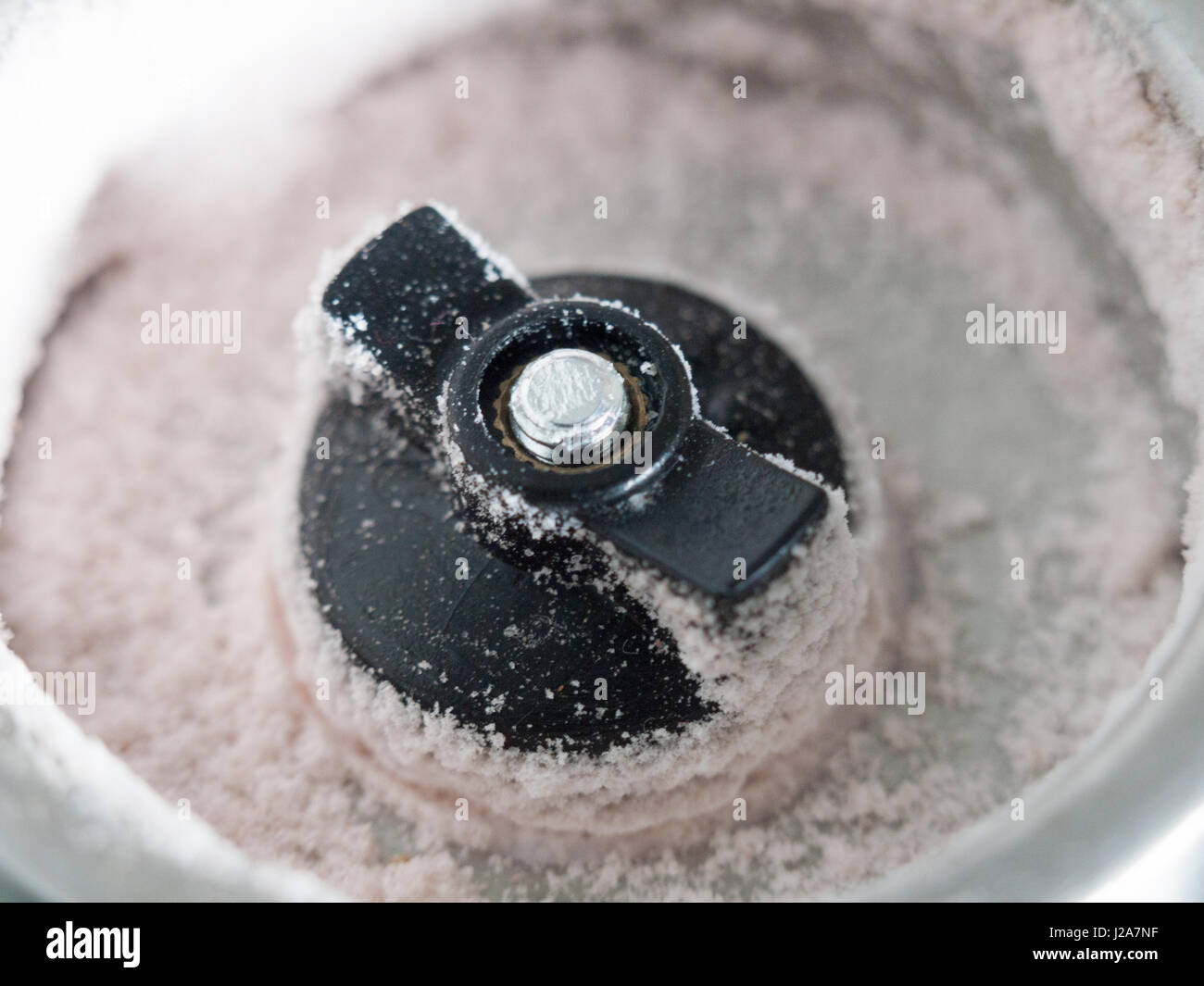 close up macro of the bottom of a salt shaker dispenser with grains of salt in detail Stock Photo