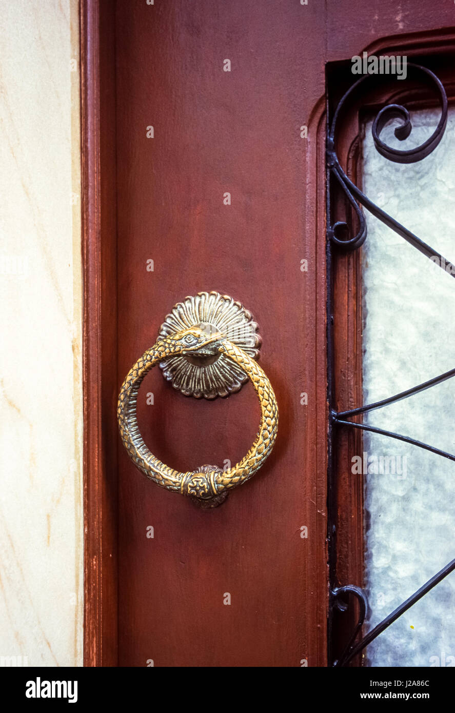 Snake shaped door knocker in the Alfama of Lisbon, Portugal. The ouroboros is an ancient symbol depicting a serpent or dragon eating its own tail Stock Photo