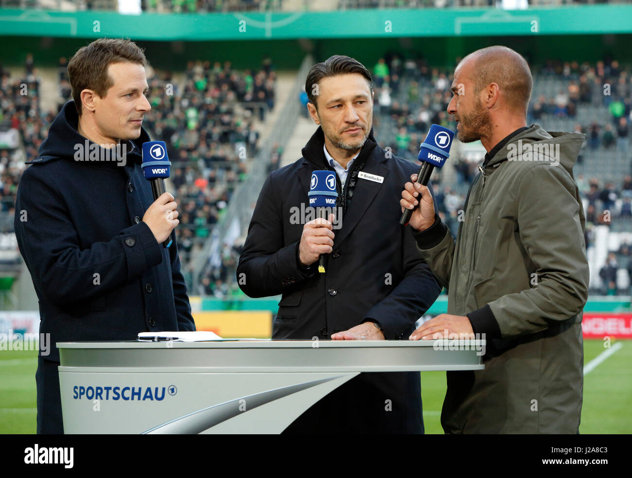 sports, football, DFB Cup, 2016/2017, Round 5, semifinal, Borussia Moenchengladbach vs Eintracht Frankfurt 7:8 on penalties, Stadium Borussia Park, television, ARD, WDR, WDR2, interview, f.l.t.r. sports reporter Alexander Bommes, head coach Nico Kovac (Frankfurt), football expert Mehmet Scholl Stock Photo