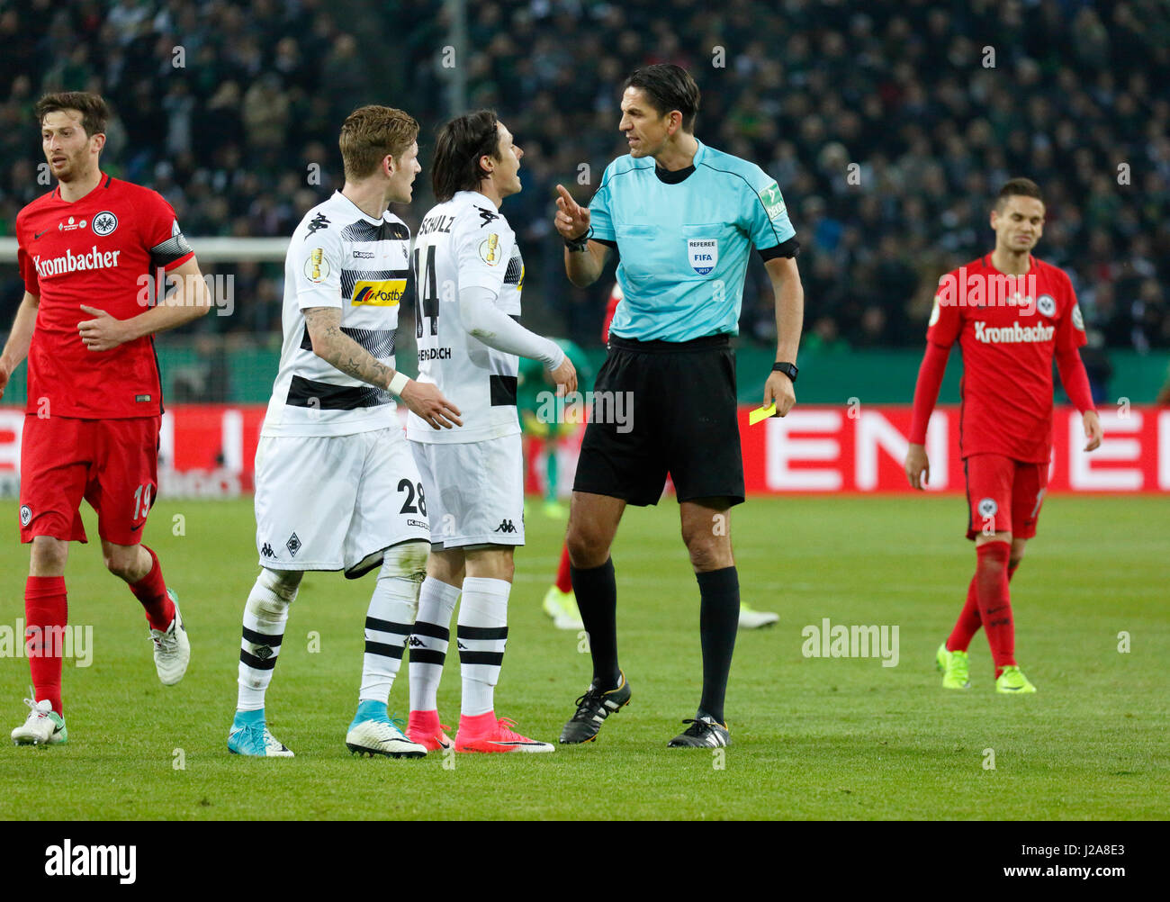 sports, football, DFB Cup, 2016/2017, Round 5, semifinal, Borussia Moenchengladbach vs Eintracht Frankfurt 7:8 on penalties, Stadium Borussia Park, scene of the match, referee Deniz Aytekin yellow-cards Nico Schulz (MG), left David Angel Abraham (Frankfurt) and Andre Hahn (MG), right Mijat Gacinovic (Frankfurt) Stock Photo