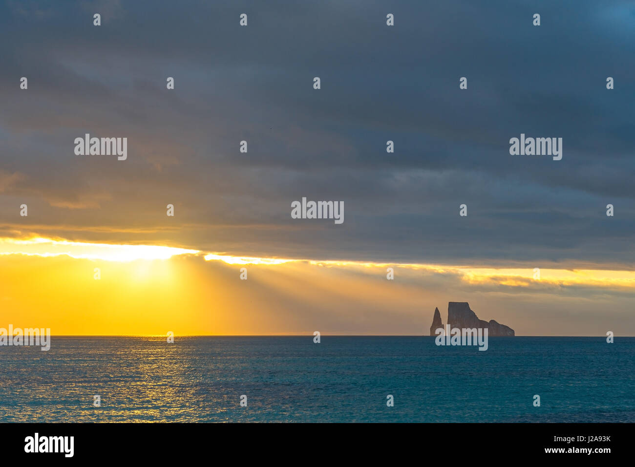 Panorama of the Kicker rock (leon dormido) at sunset with beautiful colors and sun rays in the Galapagos, Ecuador. Stock Photo