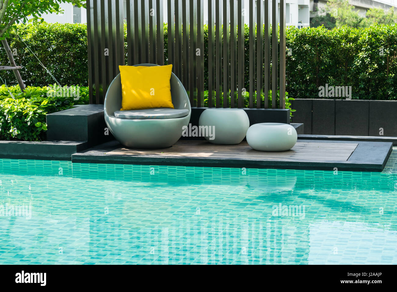 Relaxing chairs with pillows beside swimming pool Stock Photo Alamy