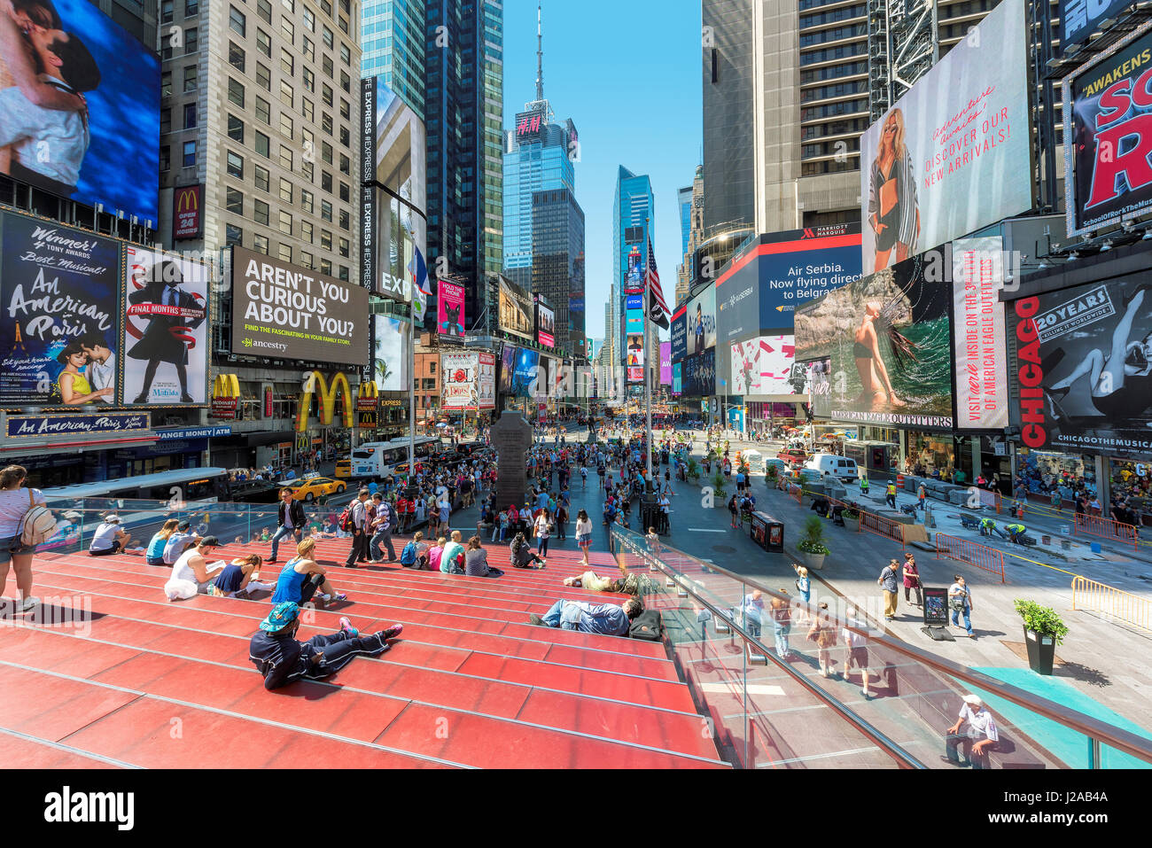 Times Square at sunny summer day with busy traffic, yellow taxi and crowds of people in Midtown Manhattan in New York City Stock Photo