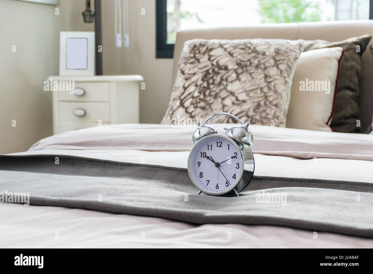 classical alarm clock on bed Stock Photo Alamy