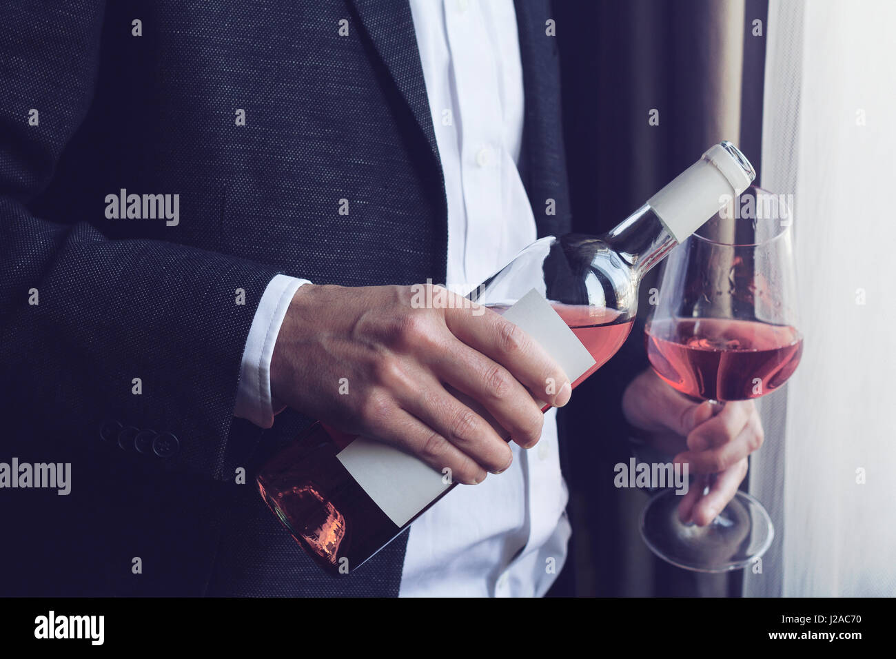 white shirt pouring rose wine into