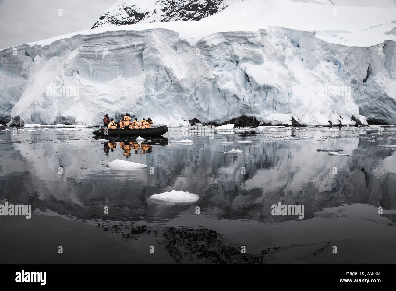 Antarctica. Tourists looking at a glacier from a Zodiac. Stock Photo