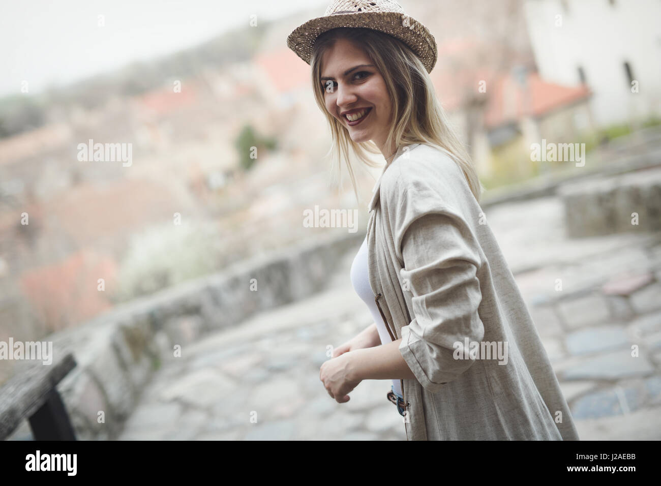 Happy blond female wearing hat outdoor and smiling Stock Photo