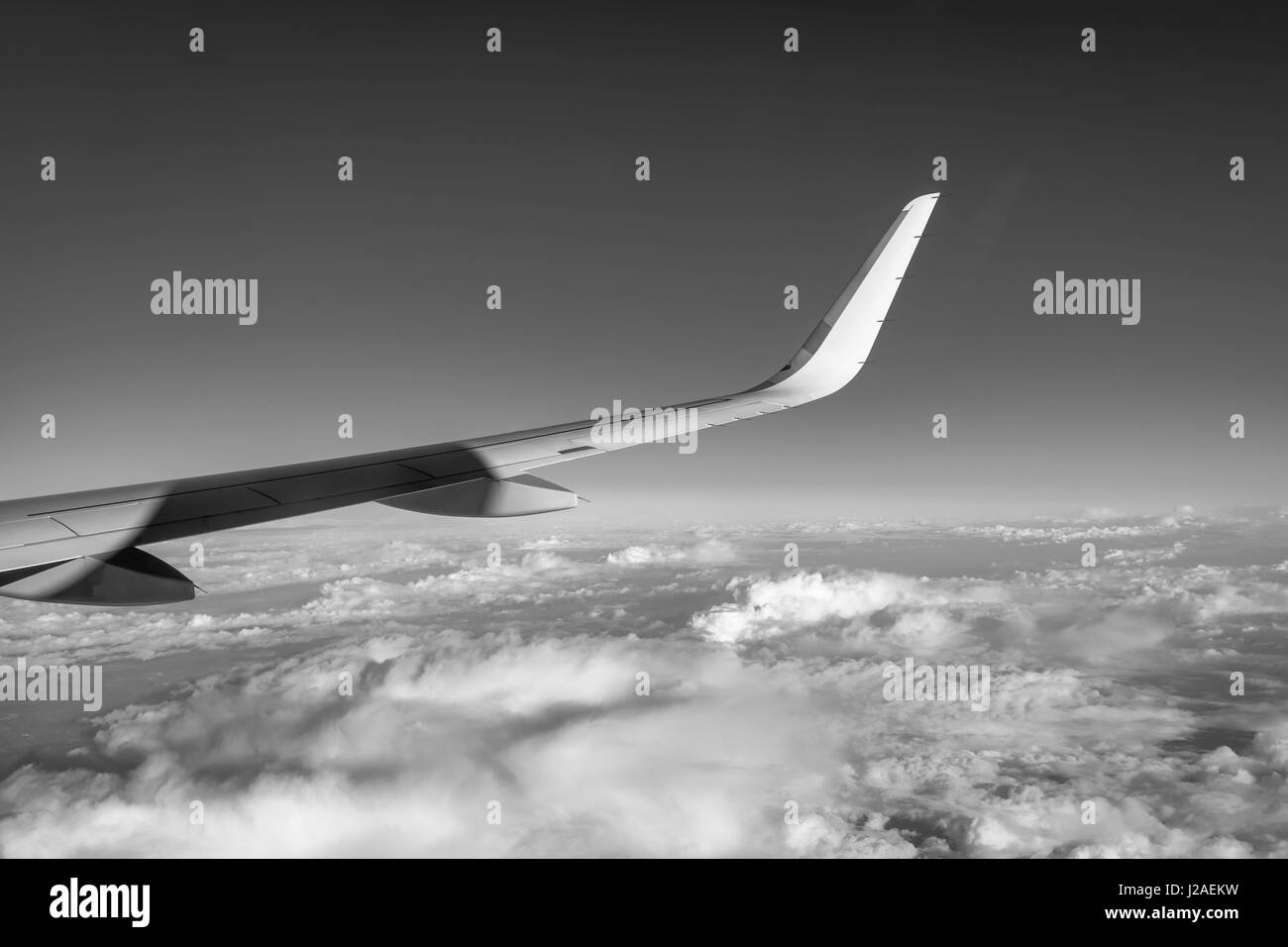 Airplane flying high above the clouds (black and white photography ...