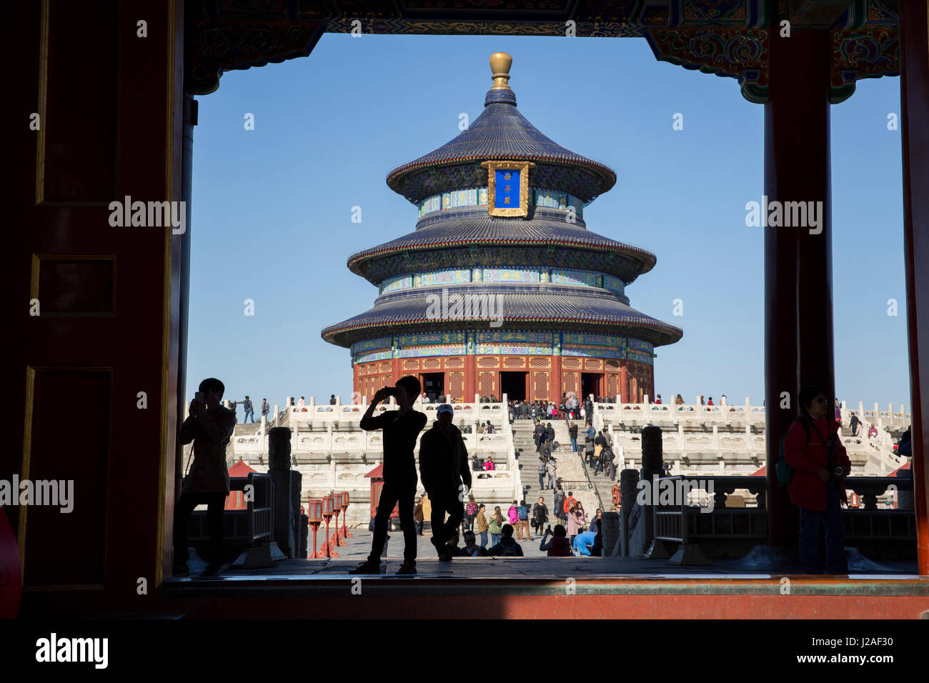 China, Beijing, Tourists take snapshots while walking through gates at Hall of Prayer for Good Harvest at Temple of Heaven Park on sunny autumn afternoon Stock Photo