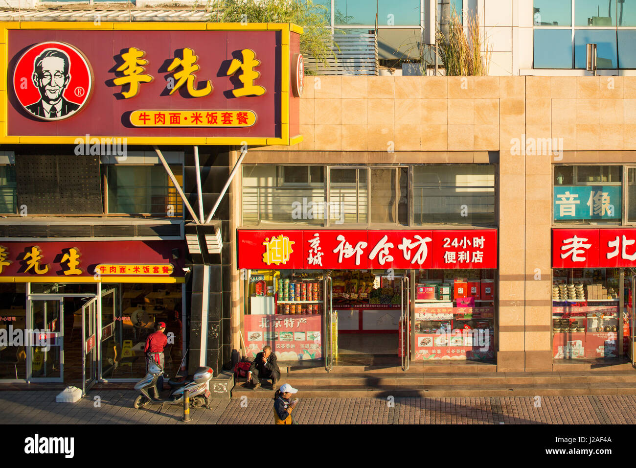 China, Beijing, Morning sun lights storefronts outside Beijing Central Railway Station along Second Ring Road in Dongcheng District Stock Photo