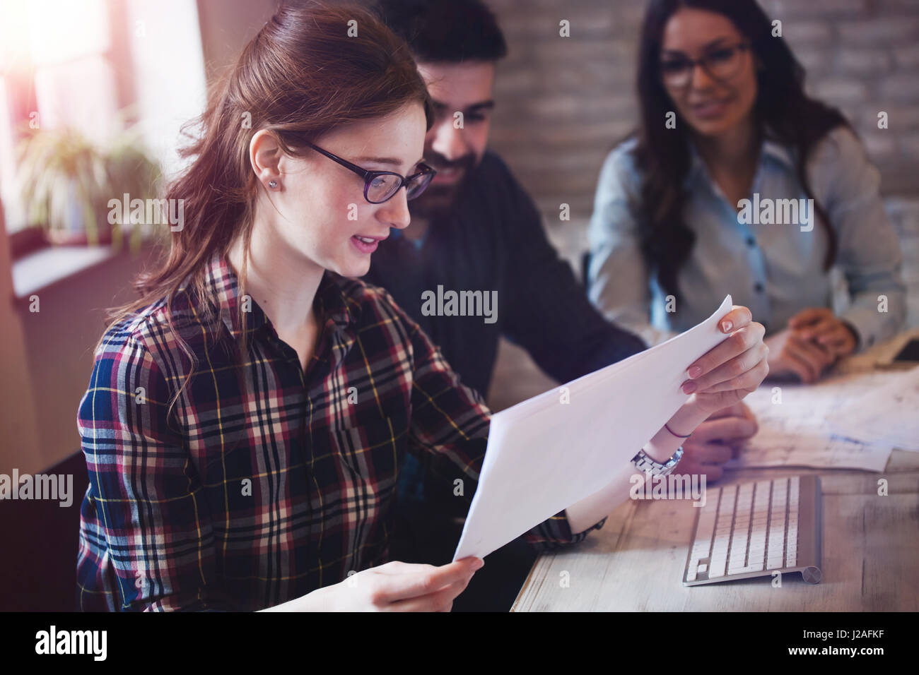 Happy female architect in office looking at blueprint Stock Photo - Alamy