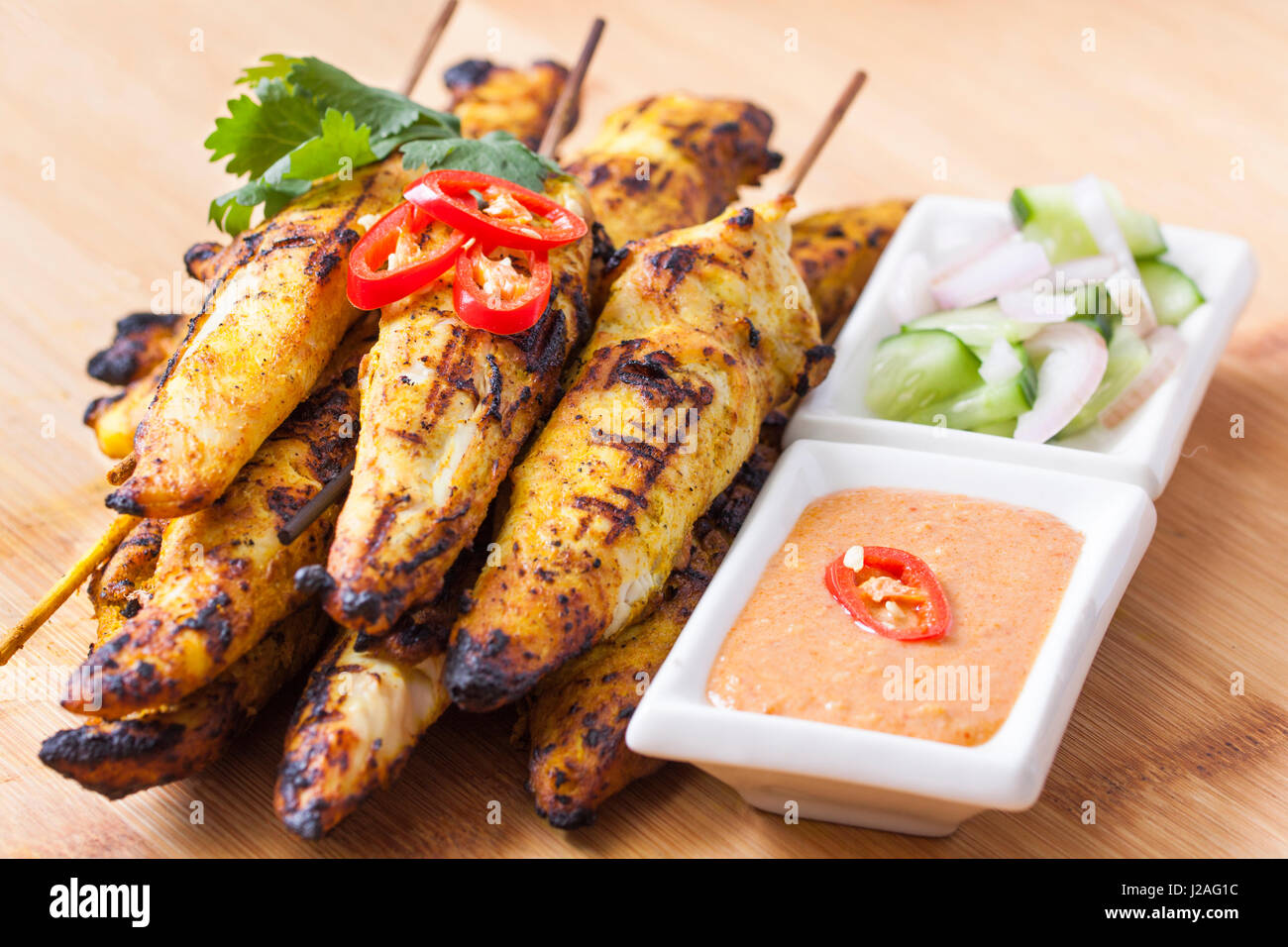 Chicken satay with peanut sauce and cucumber relish Stock Photo