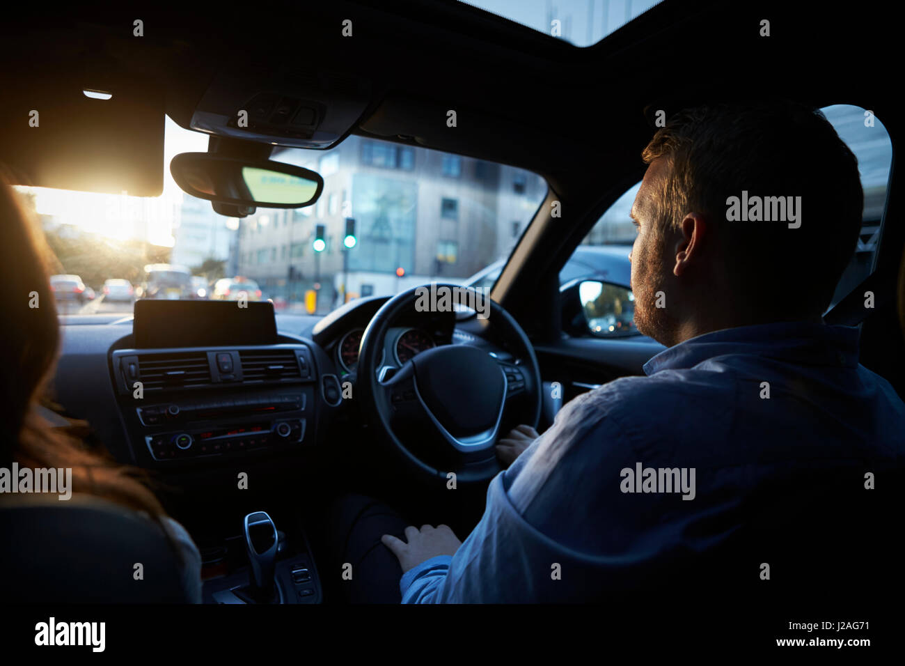 Over shoulder view of couple in car driving in the city Stock Photo
