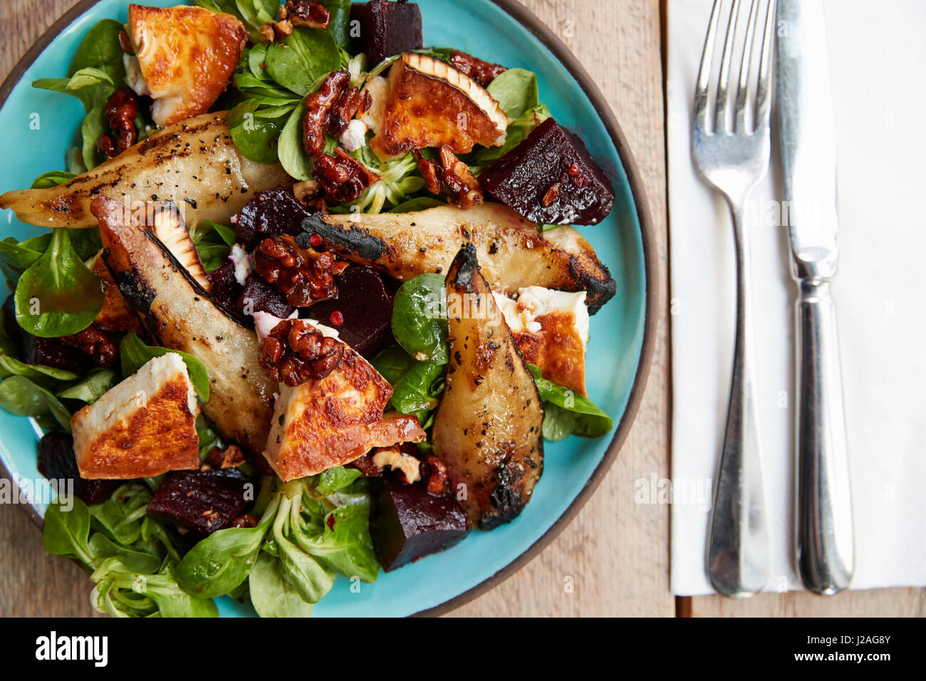 Baked goats cheese and pear salad on plate, overhead view Stock Photo
