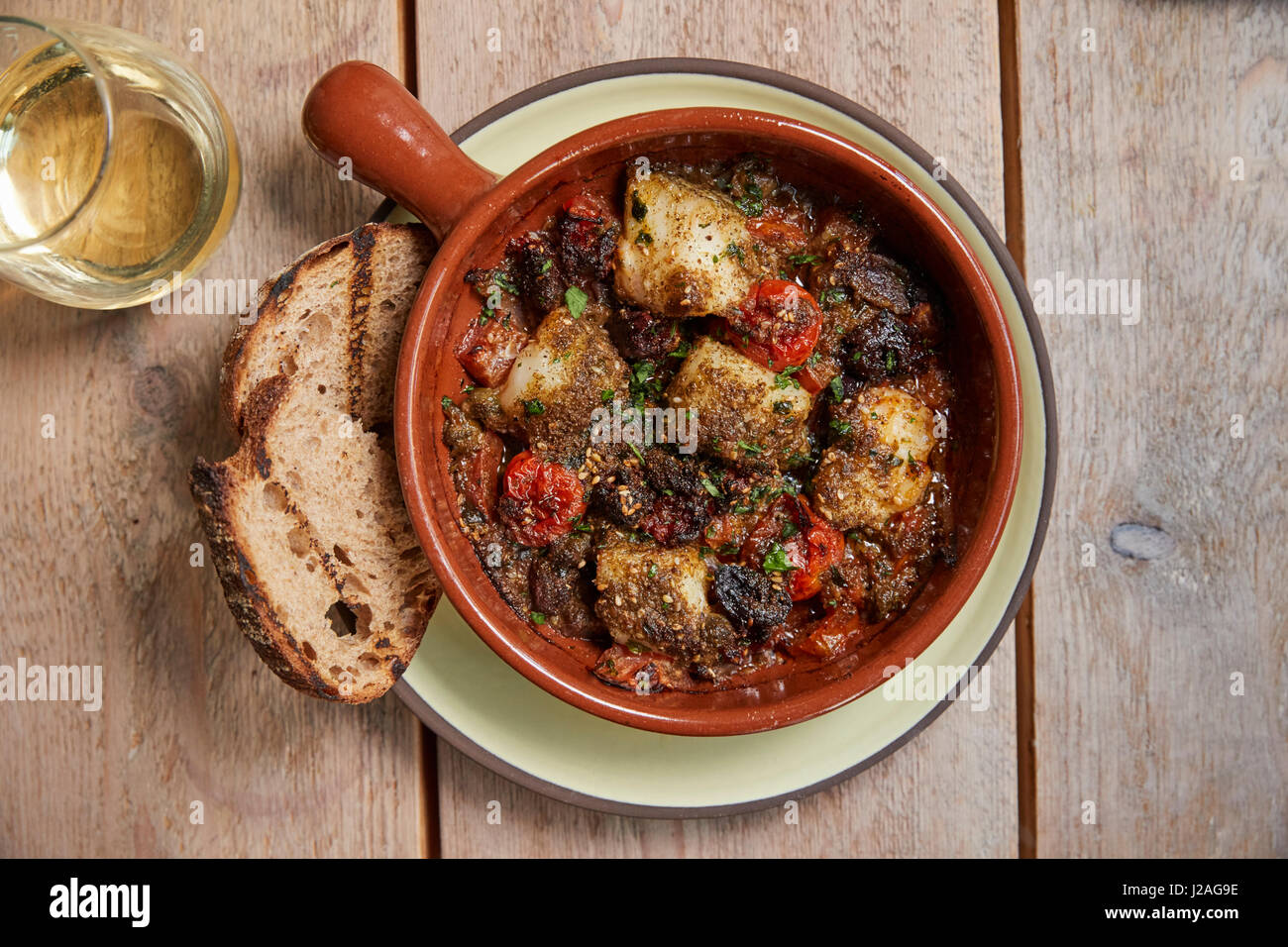 Cod and chorizo bake with grilled sourdough, overhead view Stock Photo