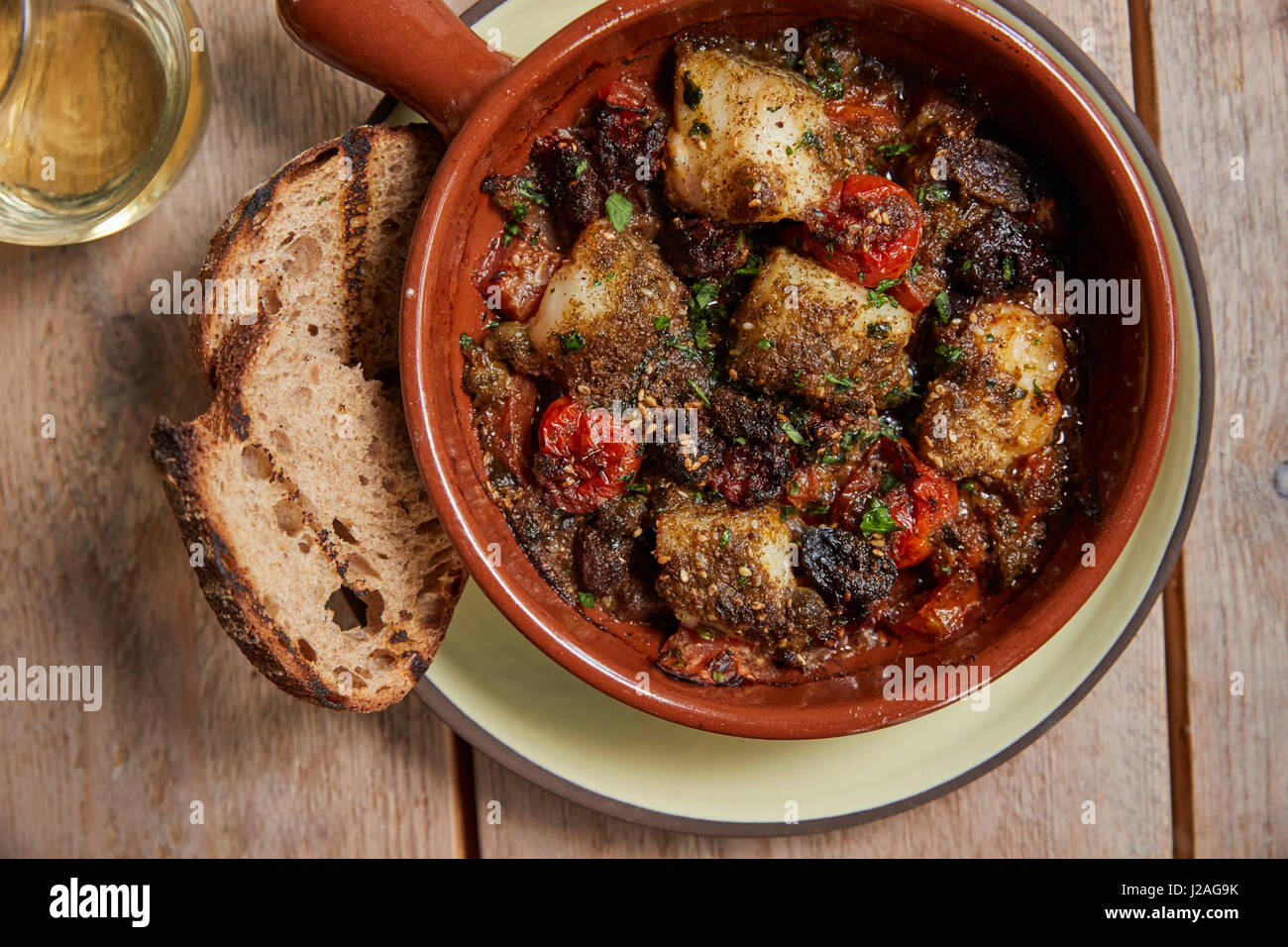 Cod and chorizo bake, grilled sourdough, overhead close up Stock Photo