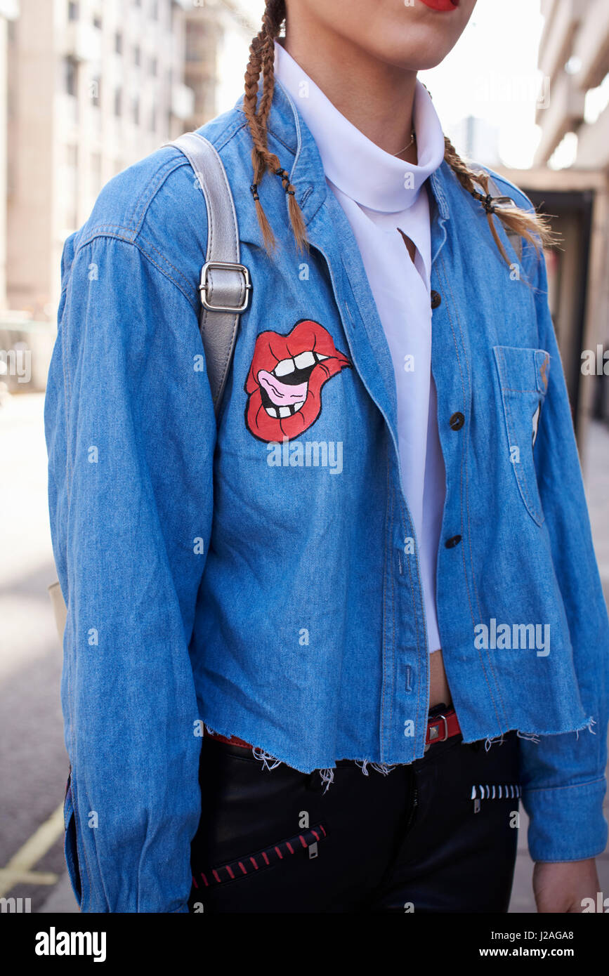 LONDON - FEBRUARY, 2017: Mid section of woman wearing decorated denim shirt in street during London Fashion Week Stock Photo