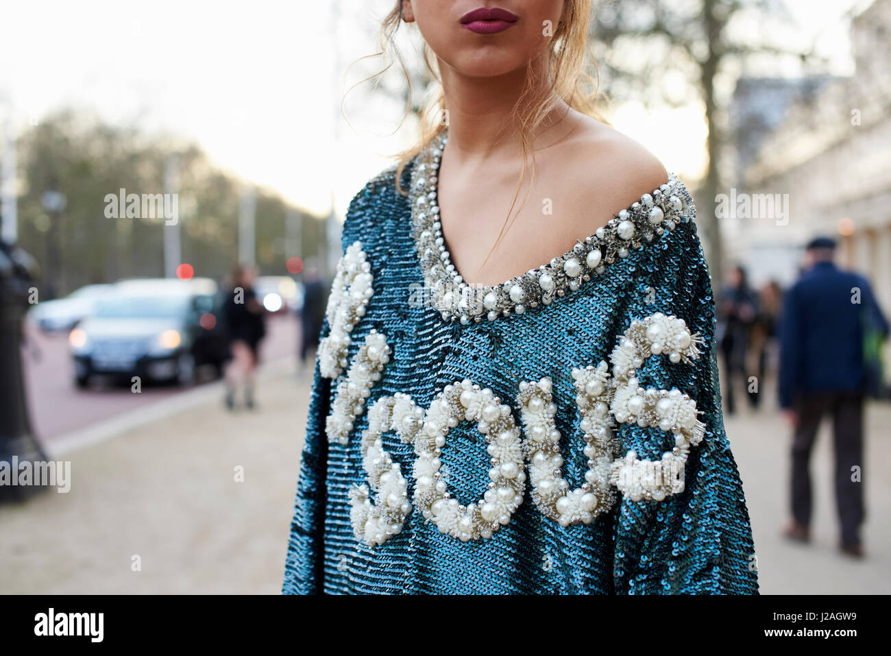 LONDON - FEBRUARY, 2017: Waist up view of female fashion blogger wearing Ashish top, standing in the street, London Fashion Week, day four. Stock Photo