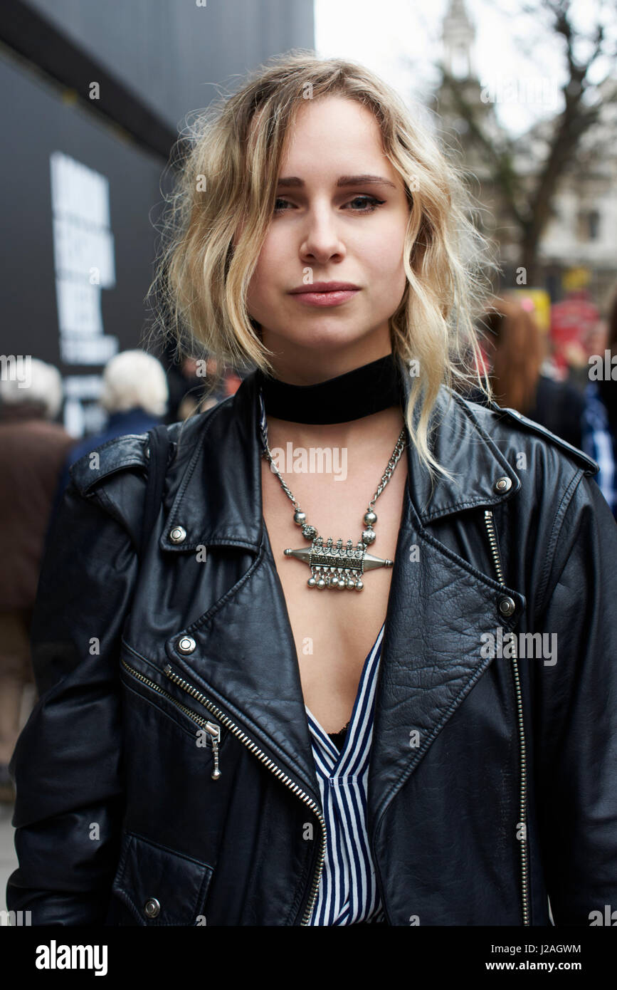 LONDON - FEBRUARY, 2017: Waist up view of woman wearing a black leather jacket, black choker and a silver tribal necklace in the street, London Fashion Week, day five. Stock Photo