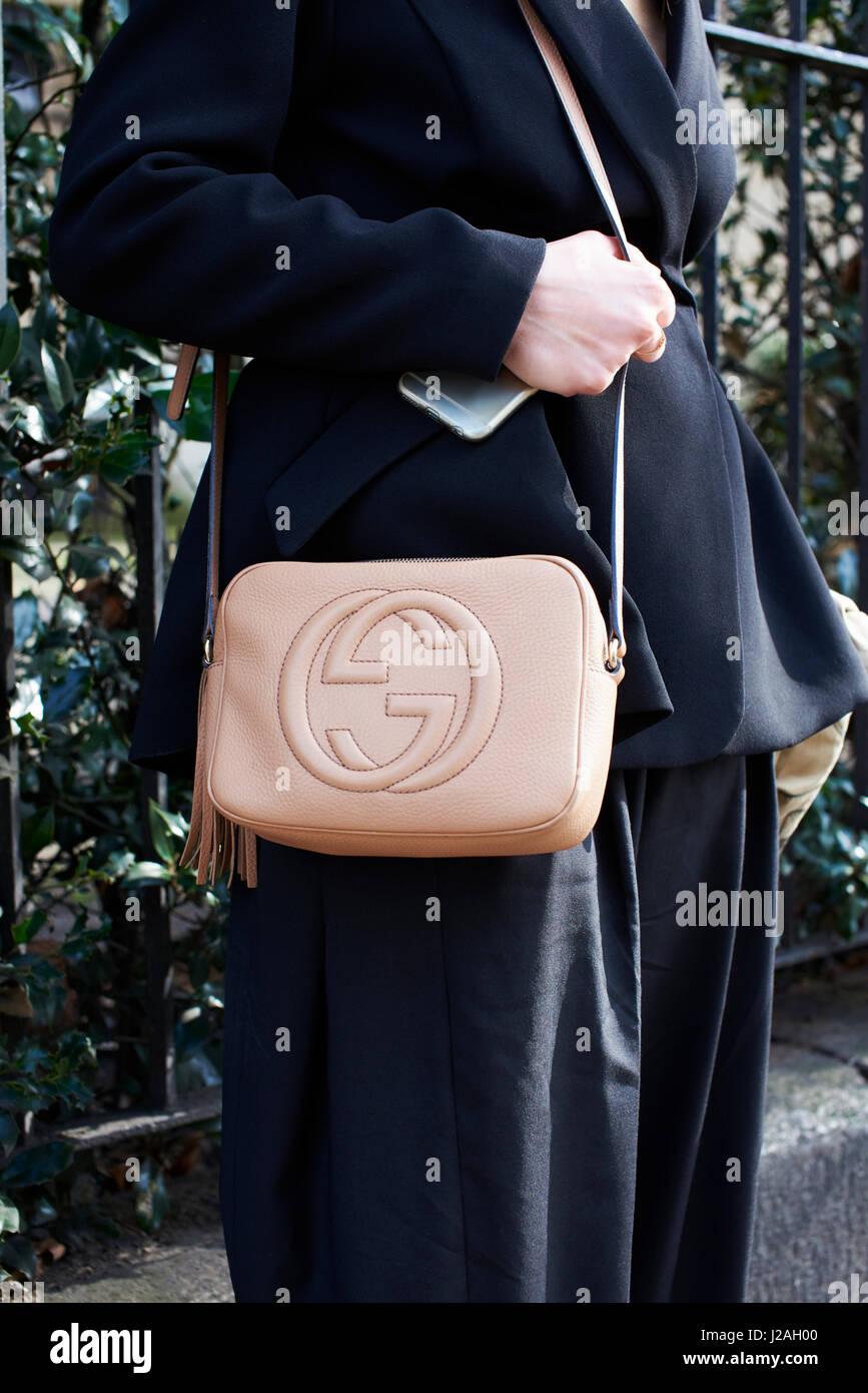 LONDON - FEBRUARY, 2017: Mid section of woman wearing brown Gucci cross body handbag standing in street outside Pringle of Scotland show, London Fashion Week, day four. Stock Photo