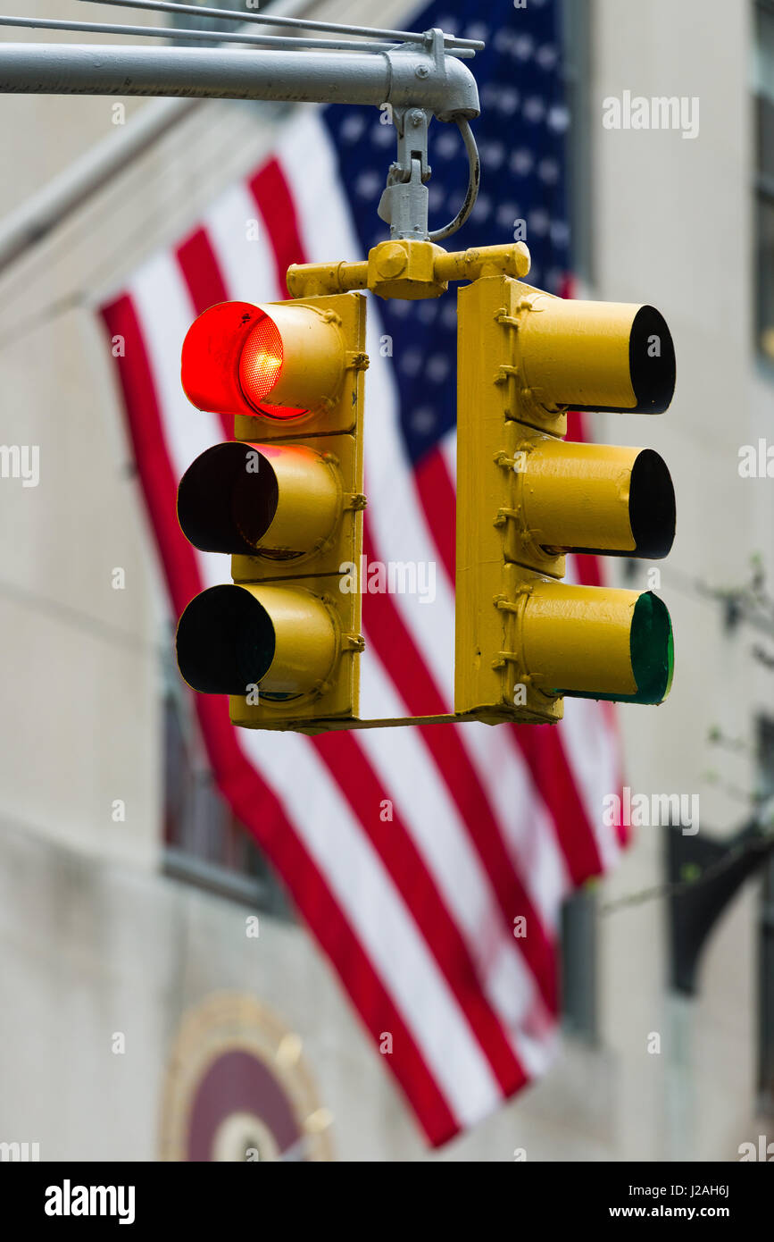 Red Traffic Light In Front Of American Flag, Immigration, Travel and Net Neutrality Restriction Concept Stock Photo