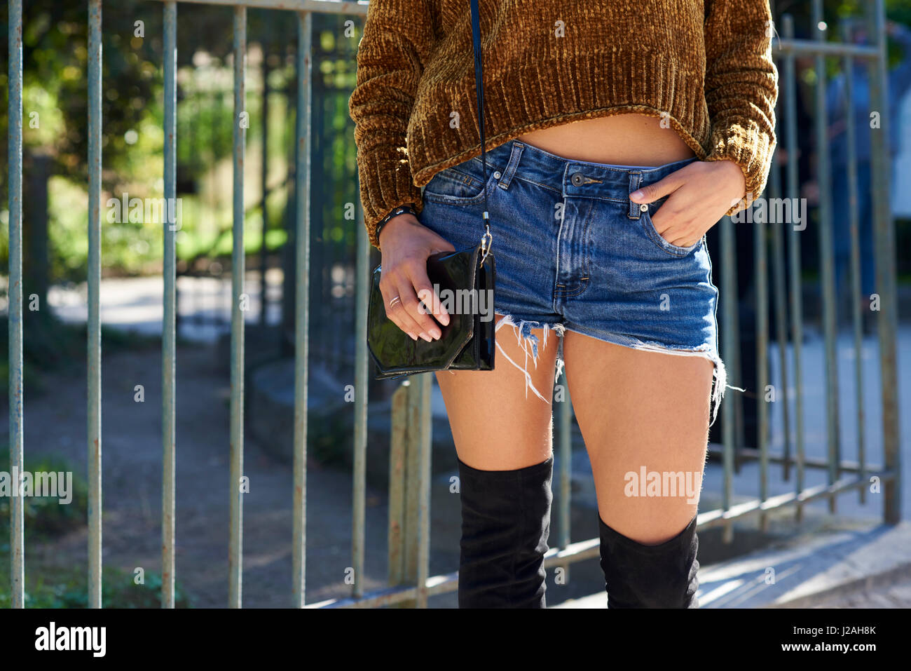 Woman in jean shorts, knitted top and thigh high boots, crop Stock Photo -  Alamy