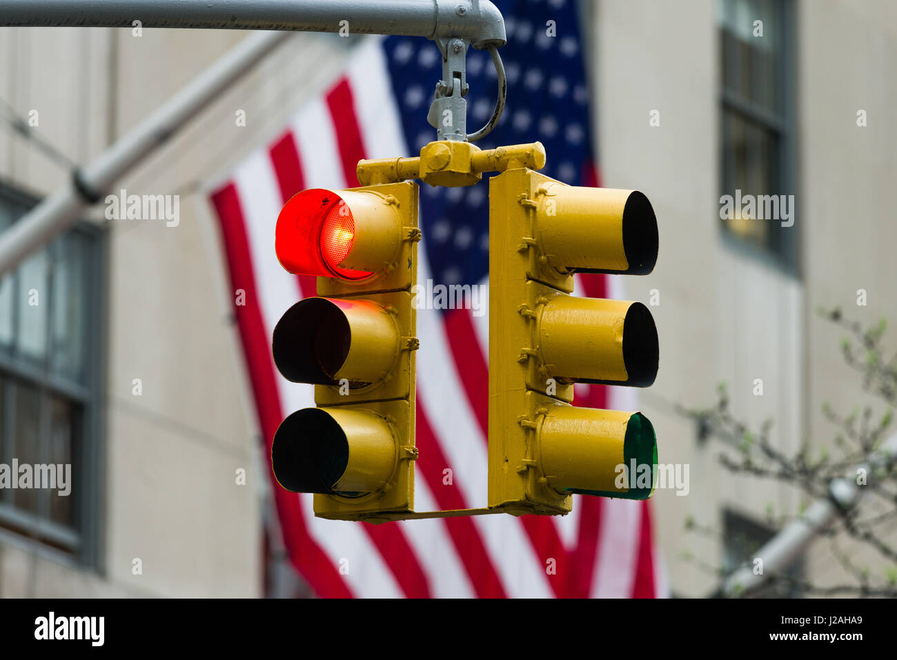 Red Traffic Light In Front Of American Flag, Immigration, Travel and Net Neutrality Restriction Concept Stock Photo
