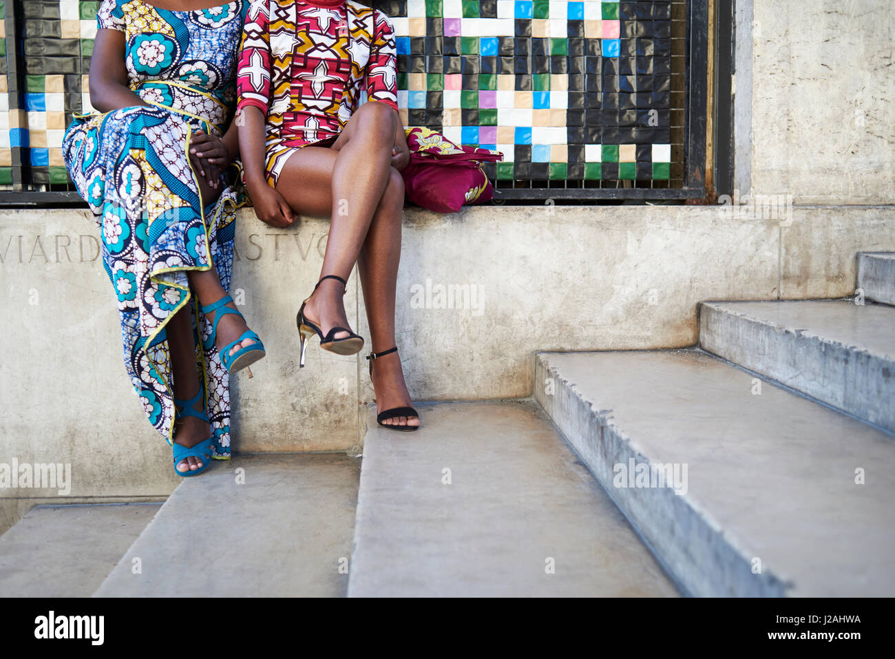 Women in colourful print dresses sitting outside, crop Stock Photo