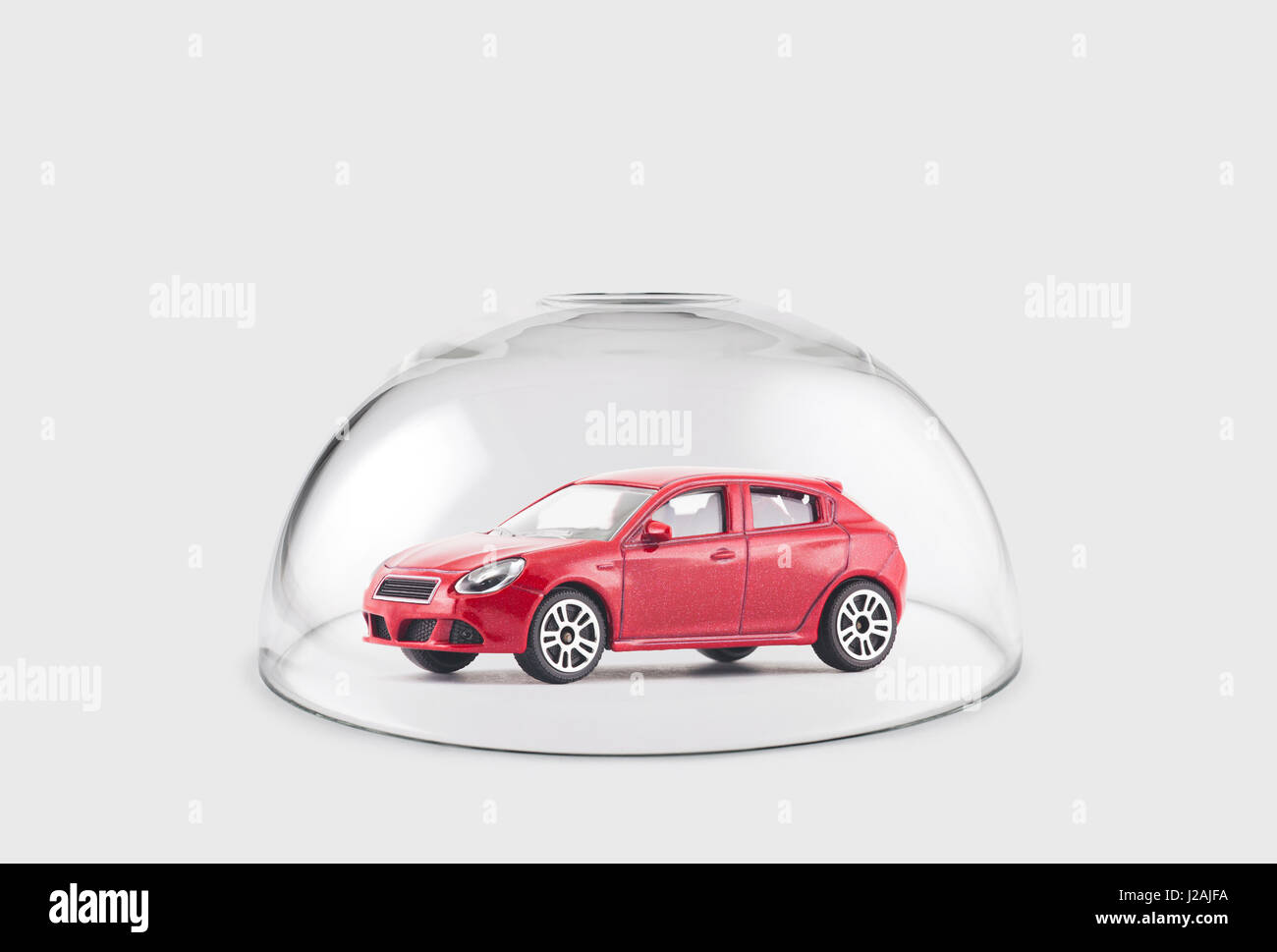 Red car protected under a glass dome Stock Photo