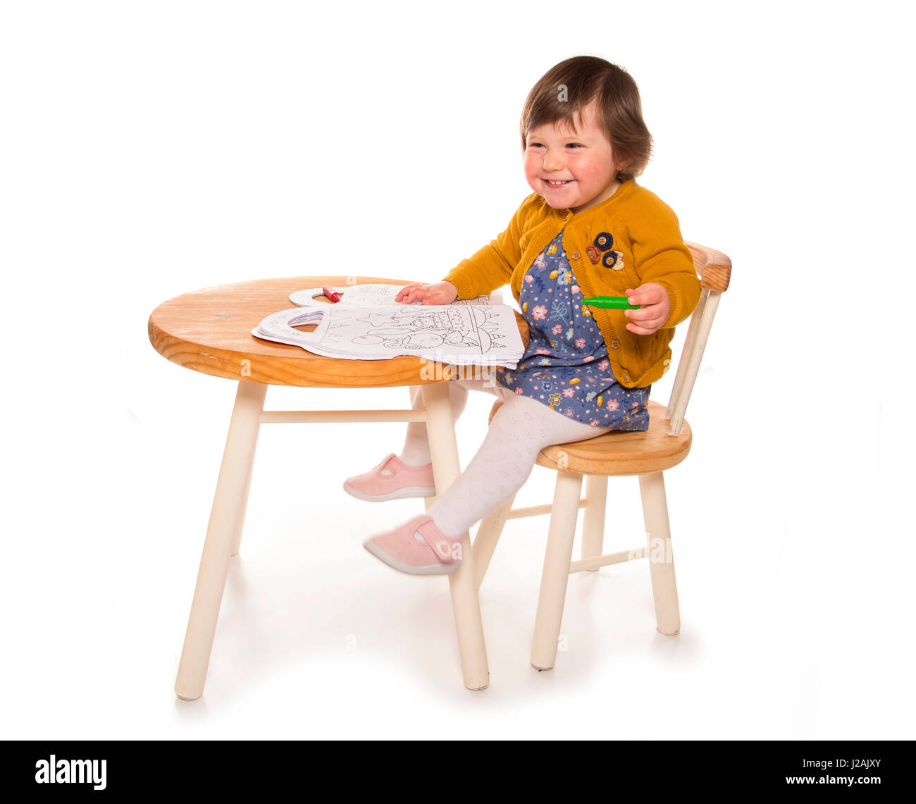 toddler at table colouring with crayon Stock Photo