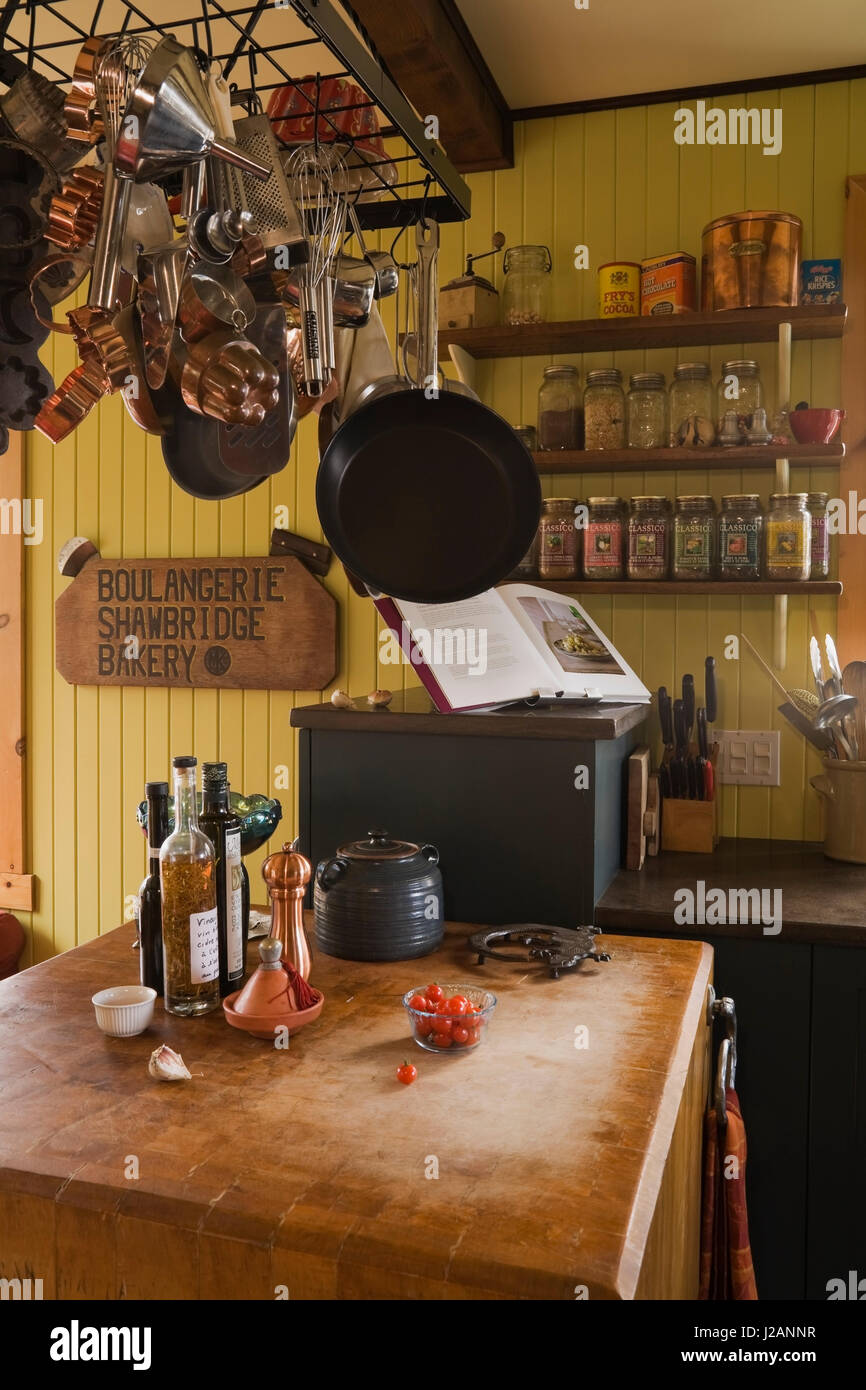 https://c8.alamy.com/comp/J2ANNR/hanging-pots-and-pans-over-a-wooden-countertop-table-in-the-kitchen-J2ANNR.jpg