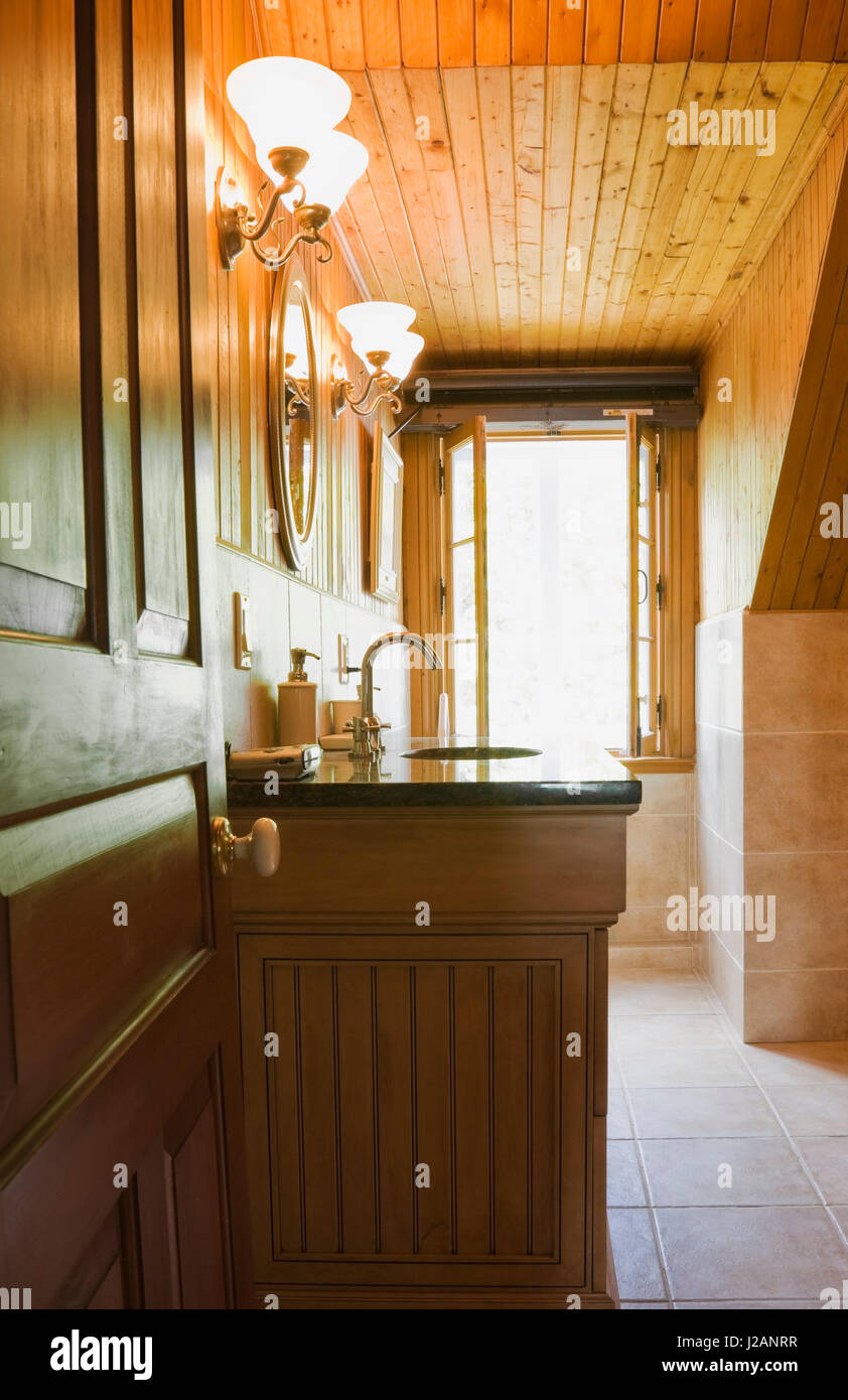 Illuminated Bathroom With Sink Encased In A Wooden Cabinet