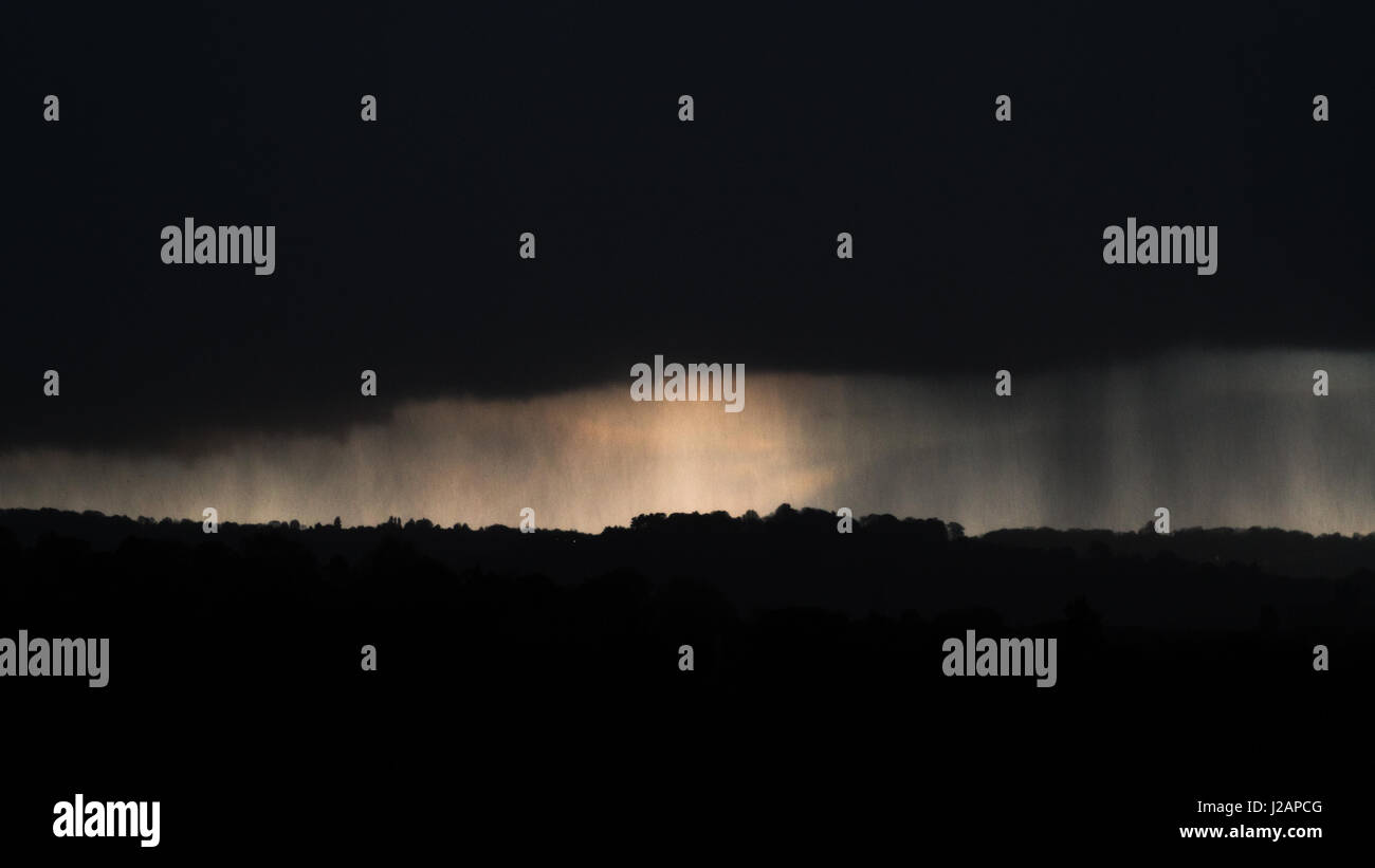 April snow falling over Bath, Somerset, UK. Dark clouds bring sleet and snow at dusk over countryside to the east of the UNESCO World Heritage city Stock Photo