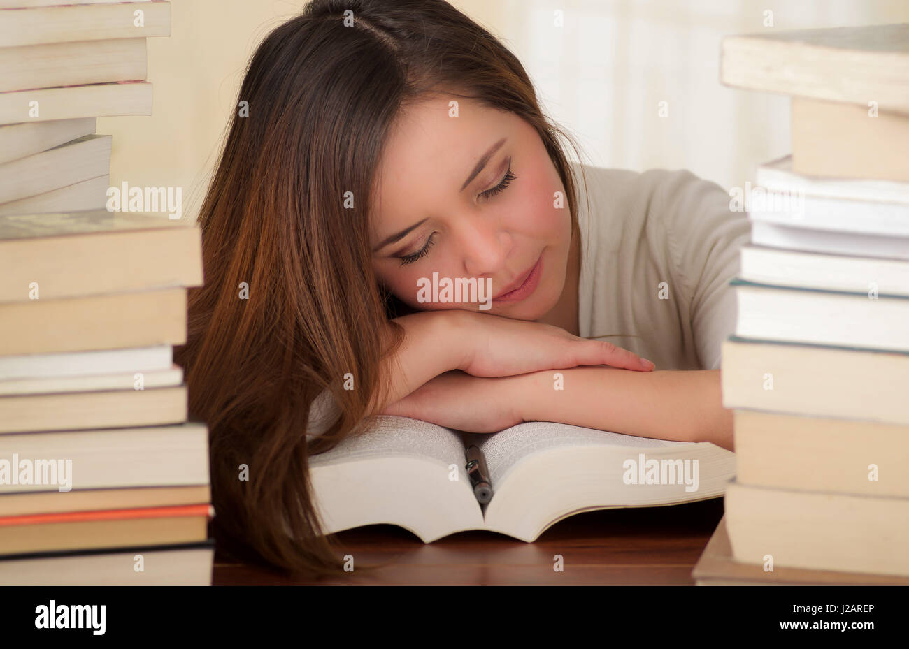 tired student completely sleep over the books in the library Stock ...