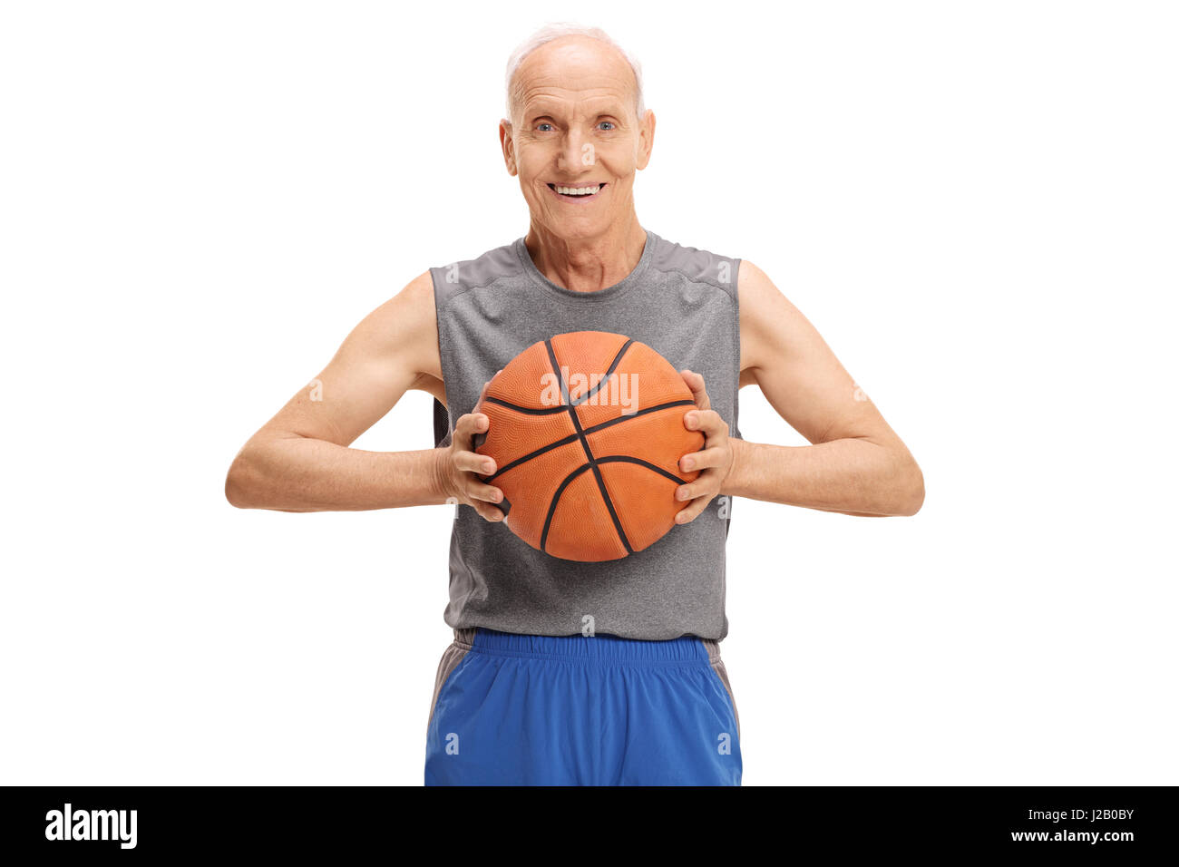 Senior with a basketball looking at the camera and smiling isolated on white background Stock Photo