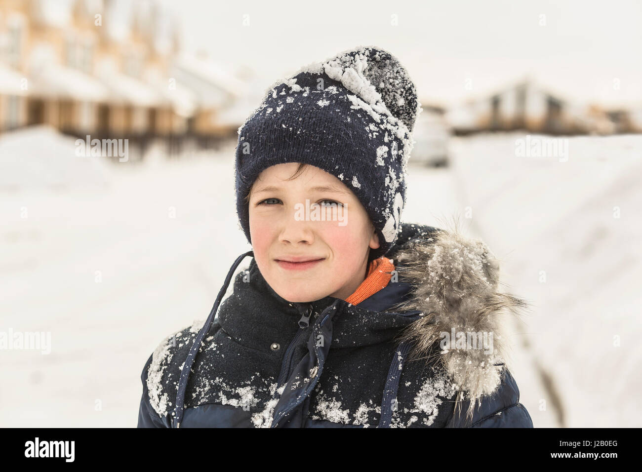 Portrait of confident boy in winter wear covered with snow Stock Photo