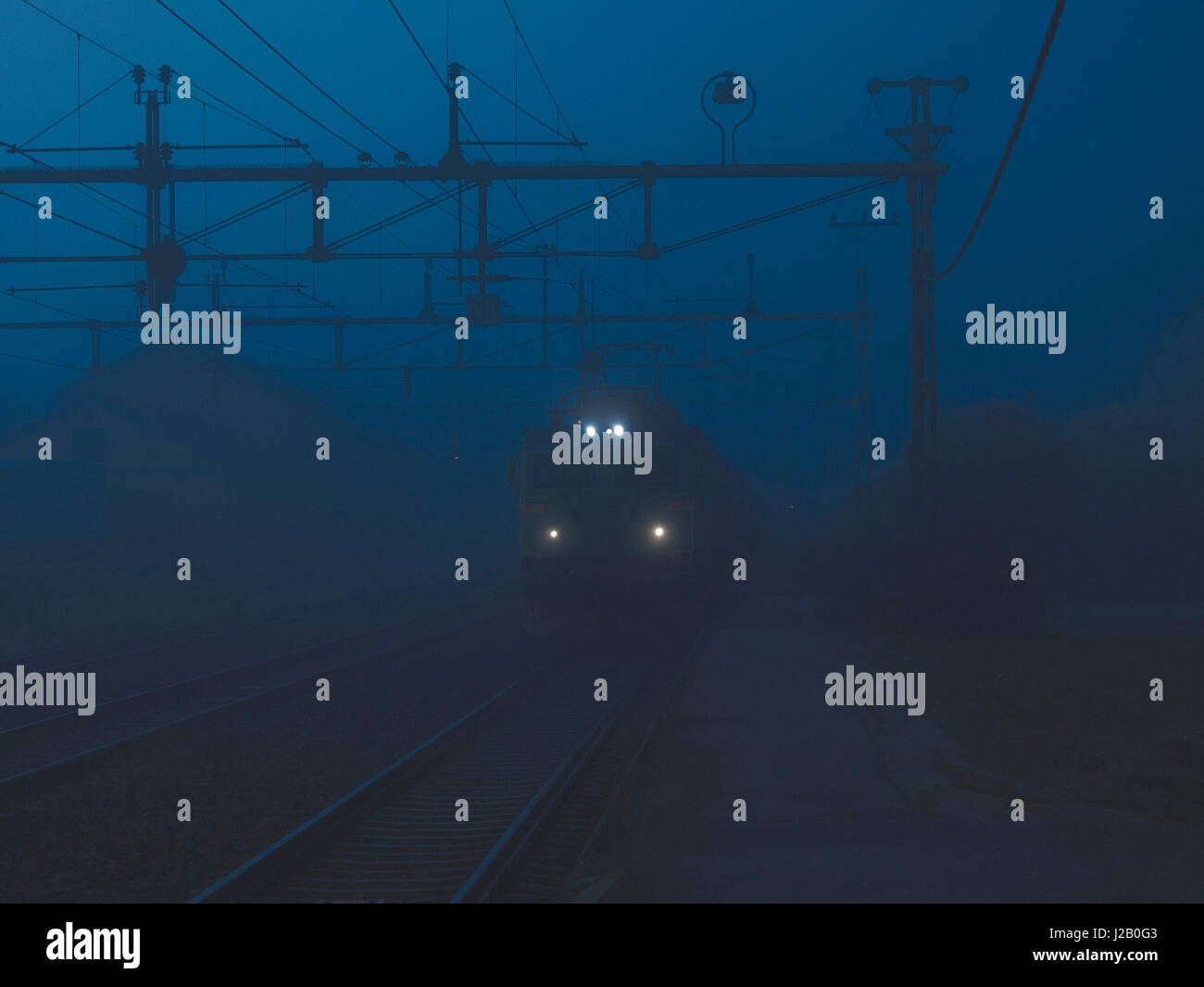 Train on railroad tracks in foggy weather Stock Photo Alamy