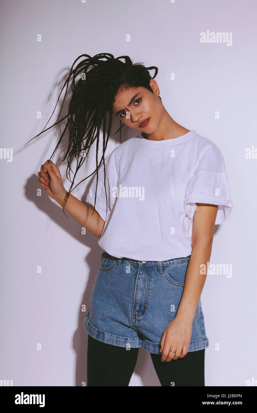 Portrait of beautiful fashion model holding dreadlocks against white background Stock Photo
