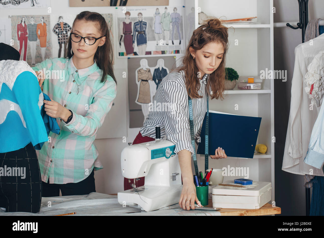Beautiful assistant by female designer working at studio Stock Photo