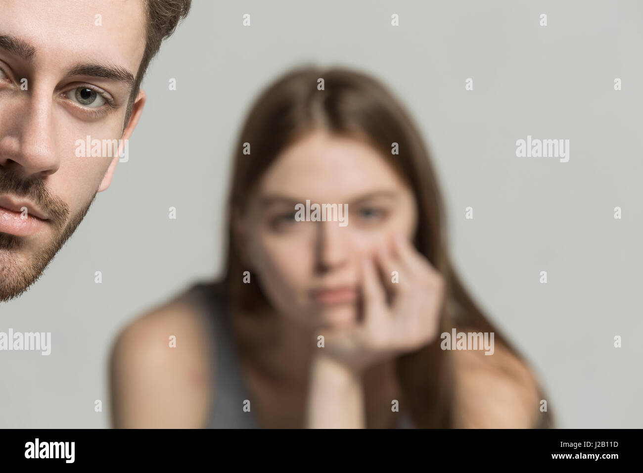 Cropped portrait of young man with woman in background Stock Photo