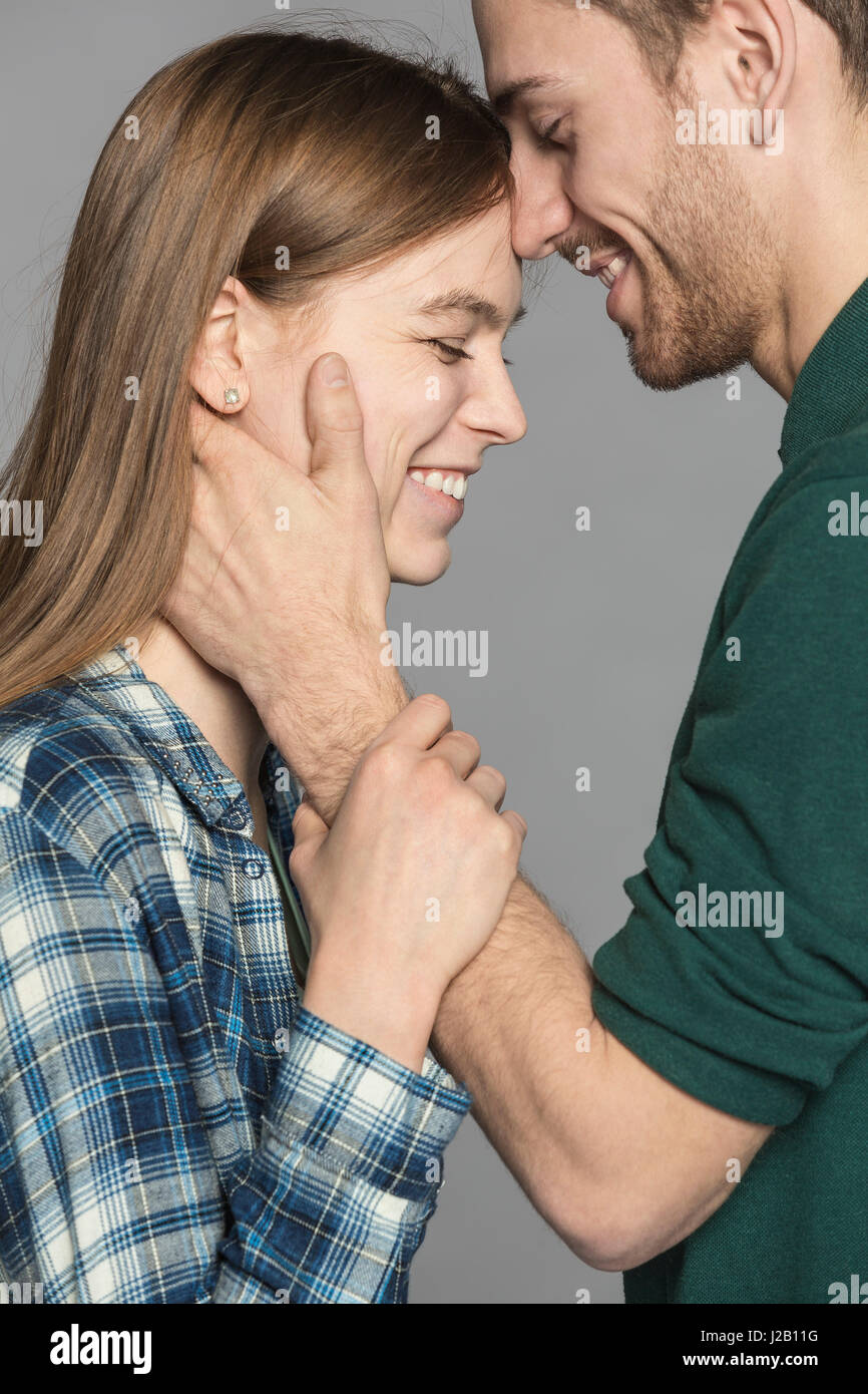 Side view of happy romantic couple against gray background Stock Photo