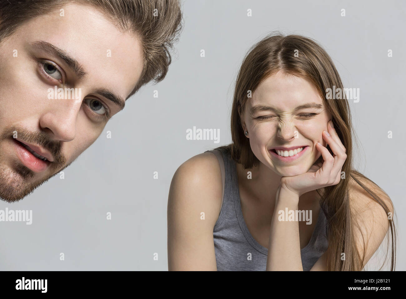 Portrait of man with cheerful girlfriend against gray background Stock Photo