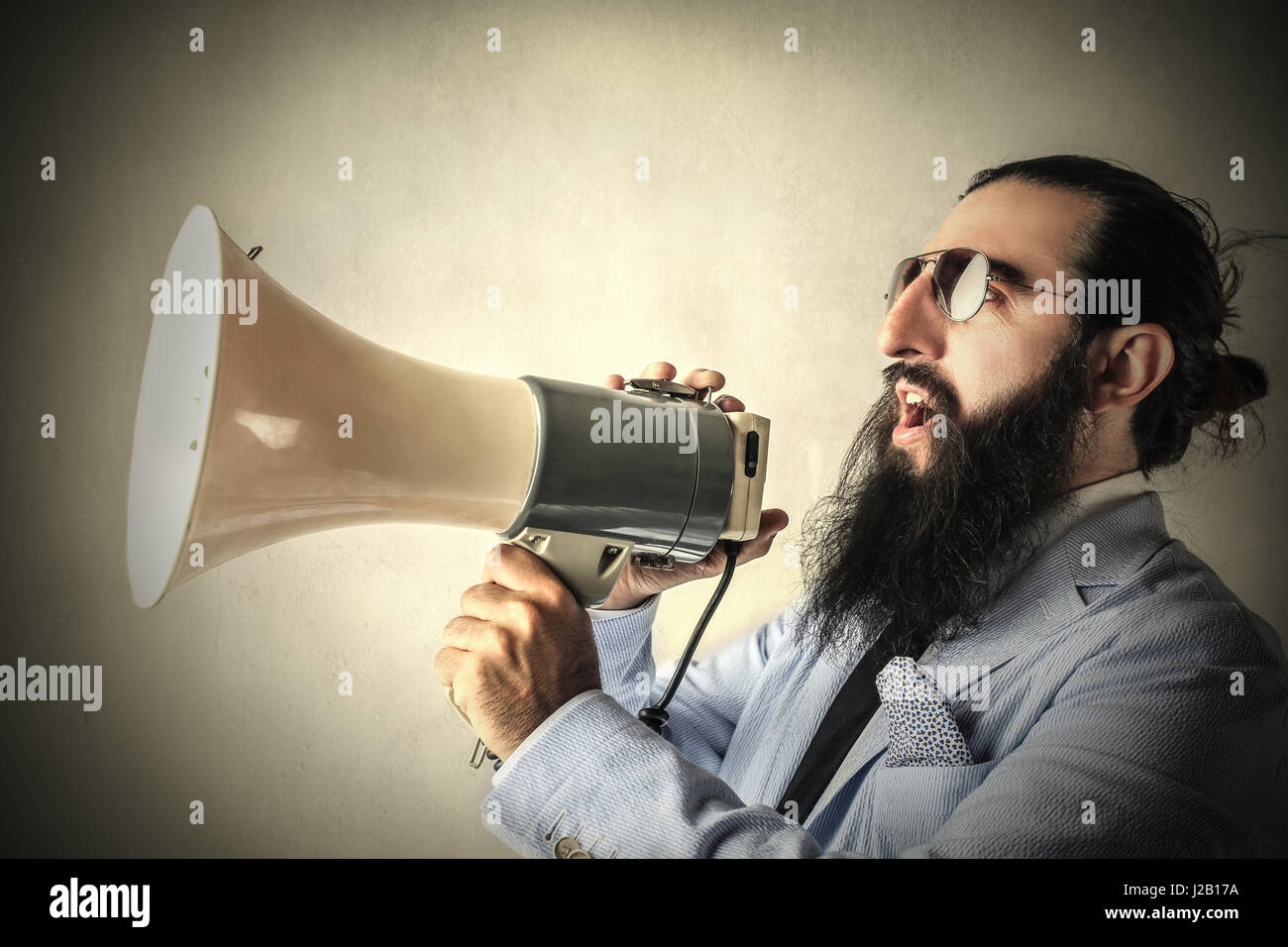 Bearded man talking into megaphone Stock Photo