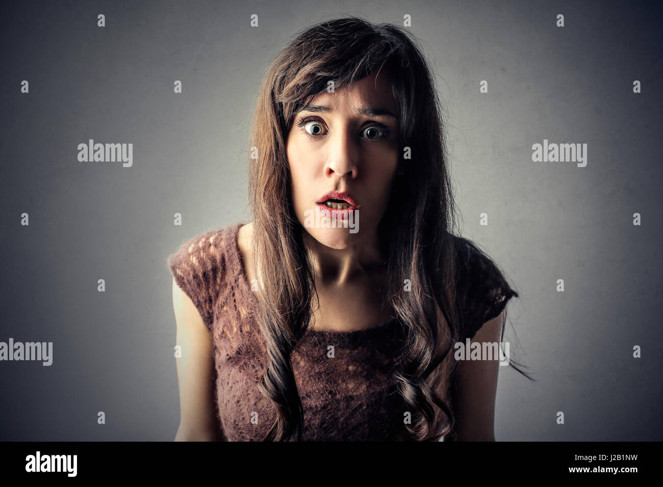 Scared woman looking into camera Stock Photo