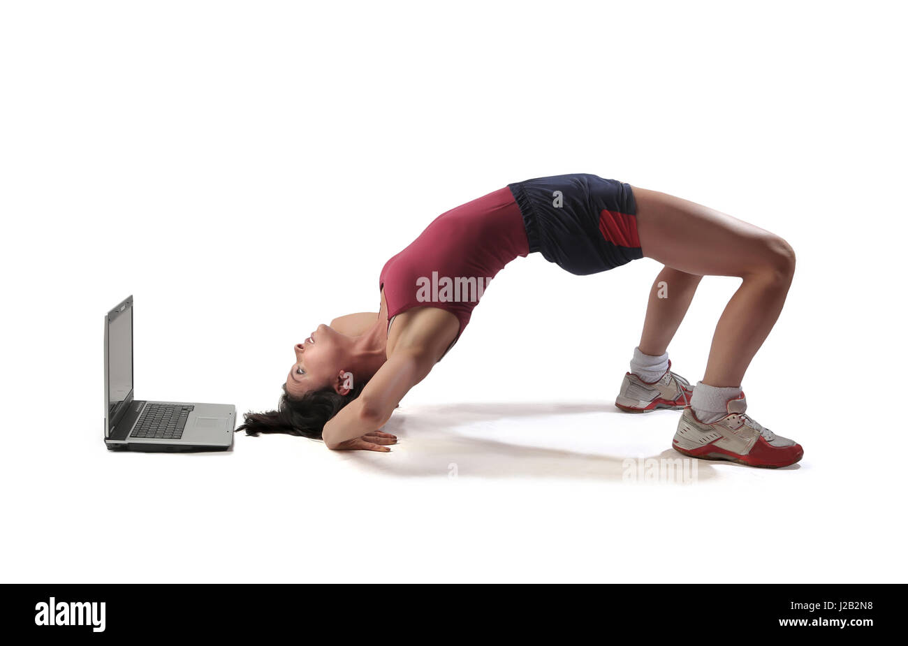 Woman doing bridge in front of laptop Stock Photo