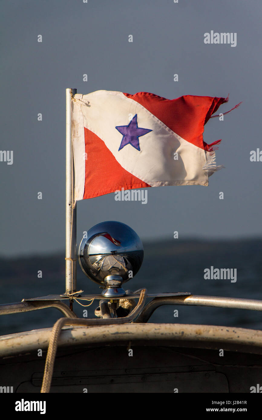 Brazilian Para state flag flies with the wind in front of a boat while crossing the Amazon river. Stock Photo