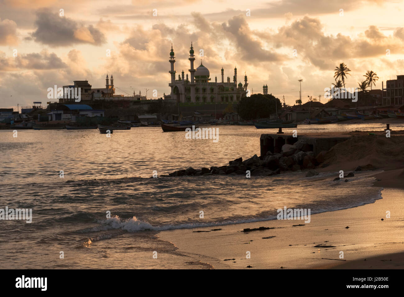 Beach of Vizhinjam town with one of the mosques in the background Stock Photo