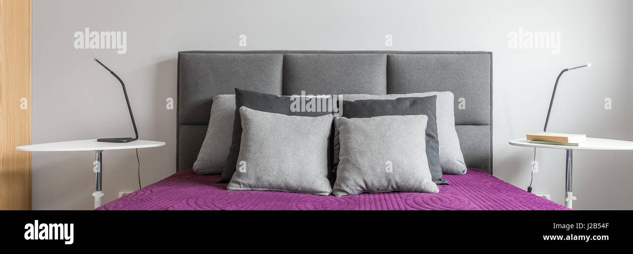 https://c8.alamy.com/comp/J2B54F/big-bed-with-grey-decorative-pillows-and-purple-bedcover-in-modern-J2B54F.jpg