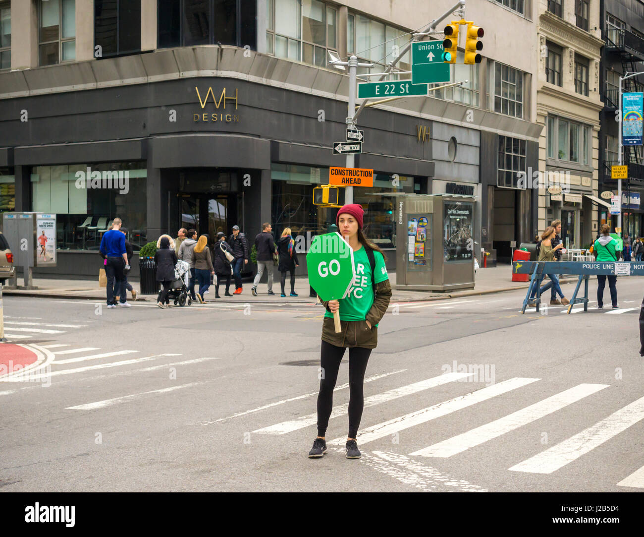 A volunteer hold a traffic stop/go sign at an intersection on Broadway during the Car Free Day in New York on Earth Day, Saturday, April 22, 2017. Broadway was closed to vehicular traffic from 42nd Street to Union Square as pedestrians strolled and bicyclists rode. (© Richard B. Levine) Stock Photo