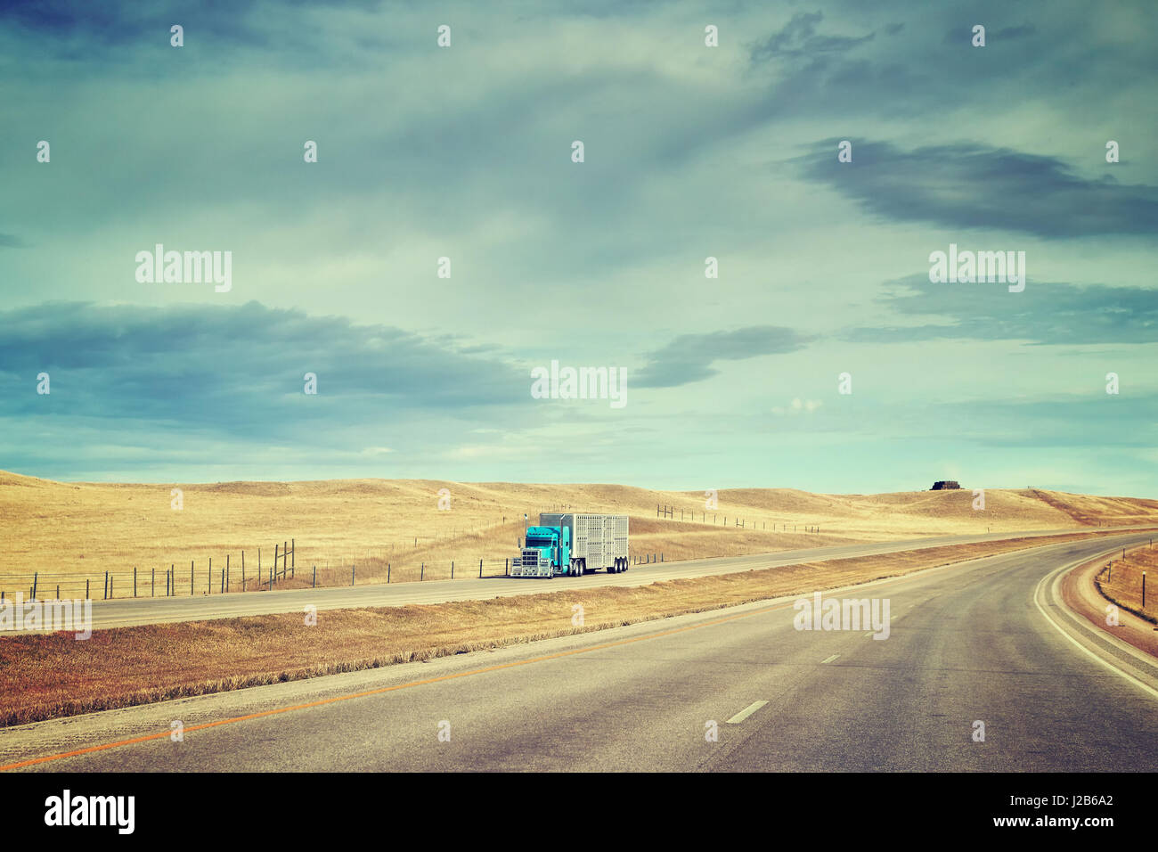 Color toned picture of American highway landscape with semi trailer truck. Stock Photo